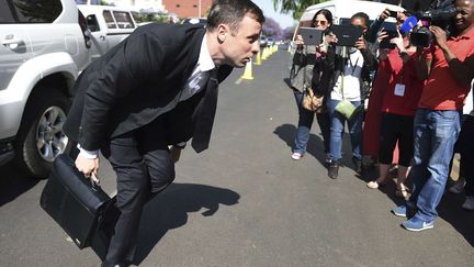 Oscar Pistorius&nbsp;ajuste son pantalon &agrave; son arriv&eacute;e au palais de justice de Pretoria (Afrique du Sud), le 17 octobre 2014. (AP / SIPA)