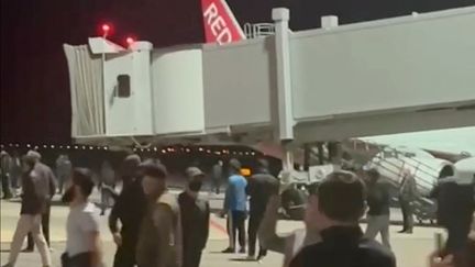 Capture d'écran d'une vidéo amateur montrant des manifestants sur le tarmac de l'aéroport de Makhatchkala, dans la région du Daguestan (Russie), le 29 octobre 2023. (- / TELEGRAM / @ASKRASUL)