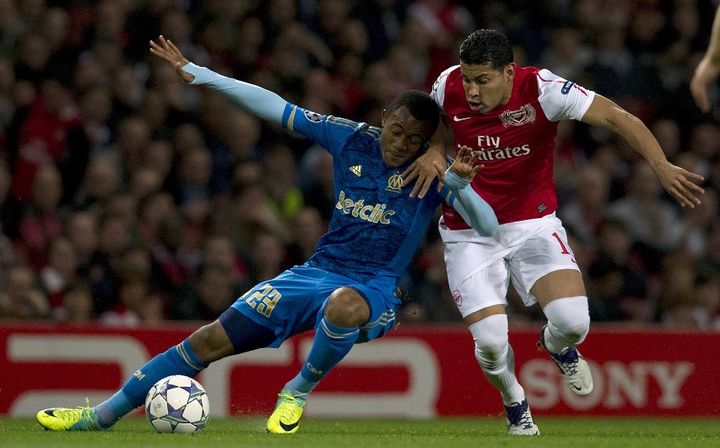 Le défenseur d'Arsenal Andre Santos (à droite, en rouge) à la lutte pour le ballon avec le joueur de Marseille Jordan Ayew, le 1er novembre 2011 à l'Emirates Stadium (Londres) en Ligue des champions. (ADRIAN DENNIS / AFP)