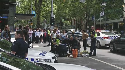 La police de Melbourne tente de secourir des piétons renversés volontairement par une voiture. (LUKE COSTIN/AP/SIPA / AP)