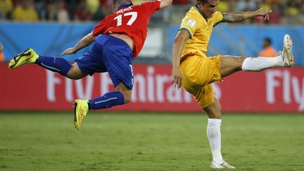 L'Australien Tim Cahill (D) et le Chilien Gary Medel lors du match opposant leurs &eacute;quipes &agrave; Cuiaba, le 13 juin 2014. (ERIC GAILLARD  / REUTERS)