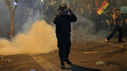 Un policier face à des manifestants, à La Paz (Bolivie), le 22 octobre 2019. (JORGE BERNAL / AFP)