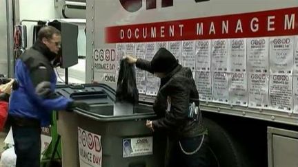 Un homme jette &agrave; la poubelle ses mauvais souvenirs de l'ann&eacute;e 2011, &agrave; New York (Etats-Unis), &agrave; l'occasion du "Good Riddance Day", le 29 d&eacute;cembre 2011. (FTVi / REUTERS)