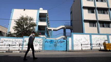 Un Palestinien passe devant une école gérée par l'Agence de l'ONU venant en aide aux réfugiés palestiniens, le 6 avril 2021 à Gaza.&nbsp; (MAJDI FATHI / NURPHOTO / AFP)