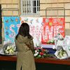 Une femme se recueille, le 26 avril 2021, devant un message et des fleurs en hommage à&nbsp;Stéphanie Monfermé, la fonctionnaire de police tuée lors d'une attaque au couteau au commissariat de Rambouillet (Yvelines). (BERTRAND GUAY / AFP)