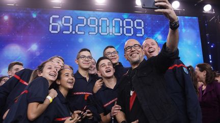 Le chanteur Pascal Obispo pose avec des pompiers lors de l'édition 2018 du Téléthon, à Paris. (GILLES SCARELLA / FRANCE TELEVISIONS / AFP)