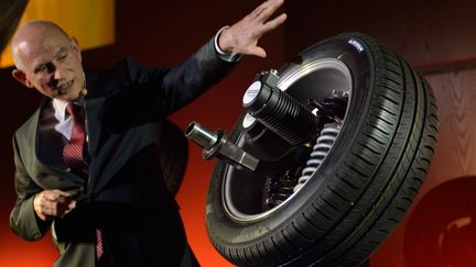 Le vice-pr&eacute;sident de Michelin pr&eacute;sente une roue &eacute;quip&eacute;e d'un moteur &eacute;lectrique lors de la premi&egrave;re &eacute;dition des&nbsp;"objets de la nouvelle France industrielle", le 19 f&eacute;vrier 2013 &agrave; Paris. (ERIC FEFERBERG / AFP)