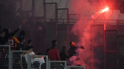 Un supporter de Galatasaray jette un fumigène dans les travées du stade Vélodrome, le 30 septembre 2021. (NICOLAS TUCAT / AFP)