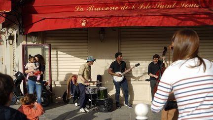 Un concert improvisé se tient devant ce café de l'île Saint-Louis, à Paris, le 24 février 2021. (MYRIAM TIRLER / HANS LUCAS / AFP)