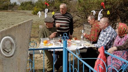 Pique-nique près du cimetière, la veille de Radunitsa. 

Cette fête religieuse reste aussi l’occasion pour les habitants du village abandonné après la catastrophe nucléaire de retrouver les anciens, qui ont quitté la zone. ( REUTERS/Vasily Fedosenko)