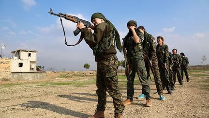 sportifs et académiques, pour résister à la tension des combats et apprendre à manier les armes. Elles se retrouvent dans un ancien moulin spécialement aménagé dans la banlieue d'al-Qahtaniyé. (AFP PHOTO / Delil Souleiman)