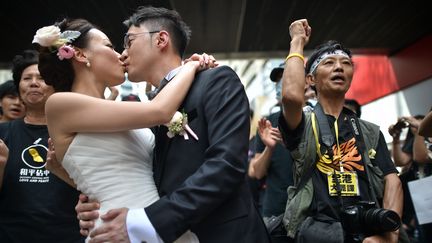 Depuis le d&eacute;but de la contestation, le mouvement, organis&eacute; notamment par le collectif "Occupy Central with Love and Peace", affiche sa non-violence. Des mari&eacute;s viennent m&ecirc;me se faire prendre en photos devant les manifestants. (PHILIPPE LOPEZ / AFP)