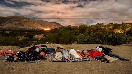 Des migrants dorment le long de l'autoroute panaméricaine entre Tulcan et Ibarra, en Equateur, le 22 août 2018. (LUIS ROBAYO / AFP)