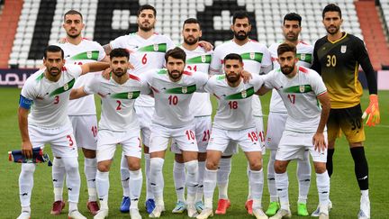 Après avoir écouté l'hymne&nbsp;vêtus&nbsp;d'une parka noire pour marquer&nbsp;leur opposition à la répression dans leur pays, les joueurs de l'équipe d'Iran ont posé pour la traditionnelle photo, avant d'affronter le Sénégal en amical, le 27 septembre 2022. (JAKUB SUKUP / AFP)