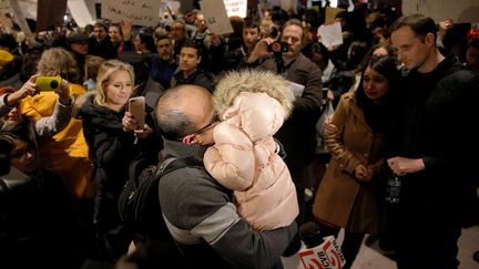 En voyage en&nbsp;Iran pour rendre visite à son père malade, cet homme retrouve sa fille à l'aéroport de Boston, après avoir été séparé des autres passagers et interrogé par la police, samedi 28 janvier 2017. (BRIAN SNYDER / REUTERS)