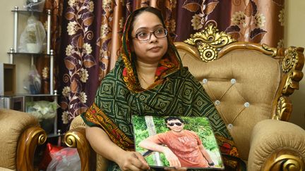 Une femme&nbsp;tient une photo de son mari, membre du Parti nationaliste du&nbsp;Bangladesh, disparu en 2013,&nbsp;le 14 août 2021, à Dacca. (MUNIR UZ ZAMAN / AFP)