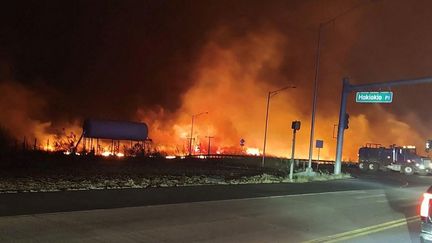 Des flammes aux abords d'une route sur l'île de Hawaï (Etats-Unis), le 9 août 2023. (ZEKE KALUA / COUNTY OF MAUI / AFP)