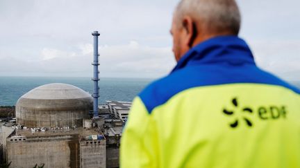 Un agent EDF devant la centrale nucléaire de Flamanville, où les premiers réacteurs pressurisés&nbsp;européens (EPR) de France sont en construction, le 16 novembre&nbsp;2016. (CHARLY TRIBALLEAU / AFP)