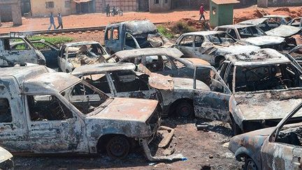 Des dizaines de voitures ont été brûlées après des affrontements dans la nuit du 6 mars 2013 à Conakry, la capitale guinéenne. La ville est en proie à des violences quotidiennes liées aux prochaines élections. (AFP PHOTO / CELLOU BINANI)