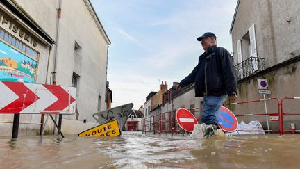 Un habitant marche dans une rue inondée du centre de Cloyes-les-Trois-Rivières (Eure-et-Loir), le 11 octobre 2024. (JEAN-FRANCOIS MONIER / AFP)