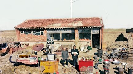 Dans diverses régions de Chine et divers milieux, Qingjun Huang a demandé à des familles de sortir de leur maison tout ce qu'ils possédaient et de poser au milieu de leurs affaires. Maigres possessions devant une yourte, ou vélo, grande télé, vases et meubles devant un immeuble moderne, "les objets domestiques eb disent long sur le niveau de vie réel des Chinois", dit le photographe qui projette de retourner voir ses sujets dans dix ans pour voir l'évolution de leur situation.
 ( Qingjun Huang © musée du quai Branly, Photoquai 2013)