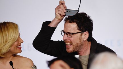 En conf&eacute;rence de presse, les stars ont parfois besoin de d&eacute;compresser : c'est le cas d'Ethan Coen, qui s'amuse ici aux c&ocirc;t&eacute;s de Sienna Miller. (LOIC VENANCE / AFP)