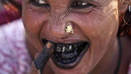 Une Indienne se nettoie les dents avec du charbon &agrave; Jammu (Inde), le 4 octobre 2012. (CHANNI ANAND / AP / SIPA)