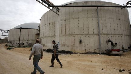 de montrer les deux immenses silos où sont stockés le fumier puis le biogaz qui sera ensuite refroidi avant d'être utilisé. (Hazem Bader/AFP)