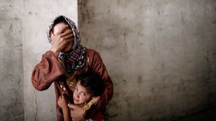 Une m&egrave;re et sa fille dans les rues d'Alep (Syrie), le 13 septembre 2012. (SAM TARLING / AFP)