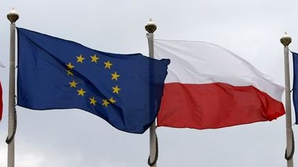 Les drapeaux de la Pologne (blanc et rouge) et  de l'UE (bleu) flottent près du Parlement polonais à Varsovie le 29 juin 2011. (Reuters - Kacper Pempel)