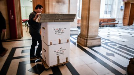 Un déménageur transporte des cartons au palais de justice de Paris, le 11 avril 2018. (STEPHANE DE SAKUTIN / AFP)