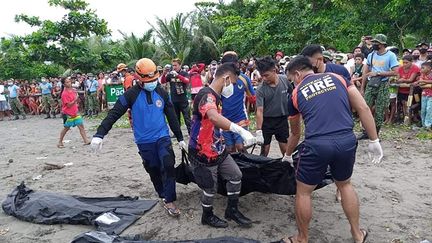 Les sauveteurs extraient des victimes de la tempête tropicale Megi, le 13 avril 2022 dans le village de Pilar (Philippines). (STRINGER / AFP)