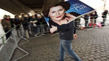 Un employ&eacute; installe une affiche promotionnelle du film "La Dame de Fer" &agrave; Londres (Royaume-Uni), le 4 janvier 2012. (JUSTIN TALLIS / AFP)