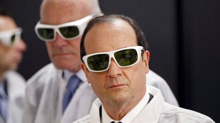 Le pr&eacute;sident fran&ccedil;ais Fran&ccedil;ois Hollande porte des lunettes de protection lors de sa visite la soci&eacute;t&eacute; Amplitude Syst&egrave;mes,&nbsp;sp&eacute;cialiste des lasers &agrave; impulsions ultra-courtes, &agrave; Pessac (Gironde), le 10 janvier 2013. (REGIS DUVIGNAU / AFP)