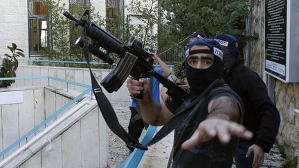 Un officier de police isra&eacute;lien gesticule devant un journaliste pr&egrave;s de la synagogue attaqu&eacute;e &agrave; J&eacute;rusalem (Isra&euml;l), le 18 novembre 2014. (RONEN ZVULUN / REUTERS)