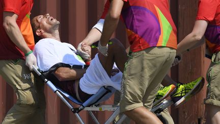 Yohann Diniz est évacué sur un fauteuil roulant à la fin du 50 km marche, aux Jeux olympiques de Rio (Brésil), le 19 août 2016. (JULIEN CROSNIER / DPPI MEDIA / AFP)