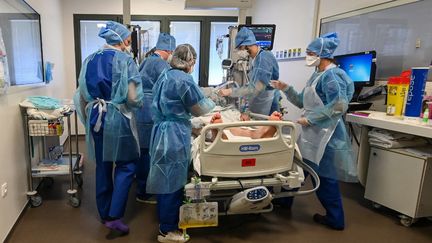 Le personnel médical s'occupe d'un patient atteint du Covid-19 et sous assistance respiratoire au service de réanimation de l'hôpital de Valenciennes (Nord), le 6 avril 2021. (DENIS CHARLET / AFP)