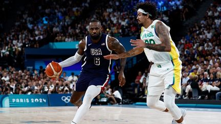 LeBron James face à Lucas Dias lors du quart de finale entre les Etats-Unis et le Brésil dans le tournoi olympique de basket, le 6 août 2024 à Bercy. (LUIS TATO / AFP)