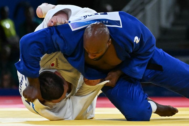 Mais Teddy Riner a un secret : il est Teddy Riner. Au bout de plus de six minutes d'un combat étouffant, il parvient à faire chuter Tatsuru Saito. Le Français met un point final à une remontada incroyable, qui permet à la France d'obtenir une 12e médaille d'or. (LUIS ROBAYO / AFP)