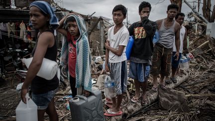 Des survivants du typhon Haiyan font la queue pour obtenir de l'eau potable à Palo, dans la banlieue de Tacloban, sur l'île orientale de Leyte, aux Philippines, le 17 novembre 2013. Plus de 6 300 personnes sont mortes dans le pays à la suite du passage du typhon. (PHILIPPE LOPEZ / AFP)