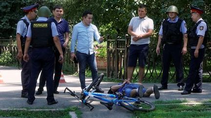 Les passants et les forces de l'ordre entourent l'un des tireurs présumés de la fusillade à Almaty. (Shamil Zhumatov)