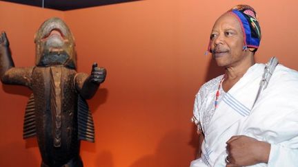 Le roi Béhanzin du Bénin pose devant un statue représentant son ancêtre au musée du Quai Branly, à Paris, le 7 avril 2010. 
 (BORIS HORVAT / AFP)