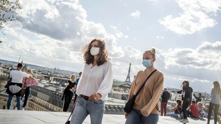 Deux passantes portant le masque sanitaire à Paris. (BRUNO LEVESQUE / MAXPPP)