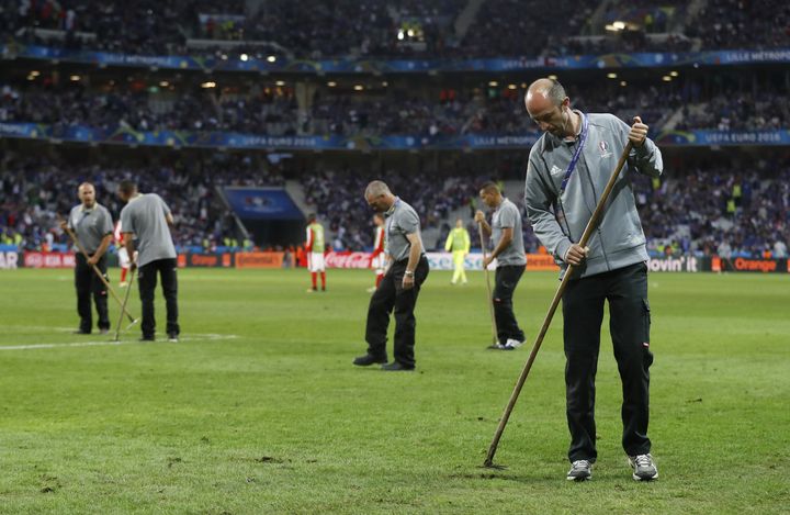 Les jardiniers tentent de reboucher les trous sur la pelouse du stade Pierre-Mauroy de Lille, dimanche 19 juin 2016. (REUTERS)