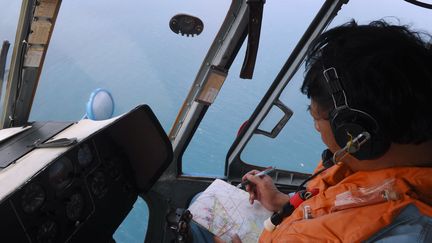 Un membre d'&eacute;quipage de l'aviation vietnamienne inspecte les eaux pour retrouver le Boeing de Malaysia Airlines disparu, le 11 mars 2014. (HOANG DINH NAM / AFP)