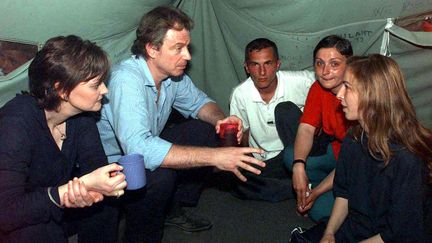 Tony Blair et sa femme, Cherie, rencontrent une famille de r&eacute;fugi&eacute;s kosovars, le 3 mai 1999. (JOHN STILLWELL / POOL)