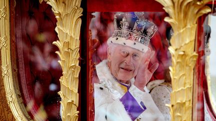 Le roi Charles III salue la foule après la cérémonie de son couronnement à l'abbaye de Westminster, à Londres (Royaume-Uni), le 6 mai 2023. (ROB PINNEY / POOL / AFP)