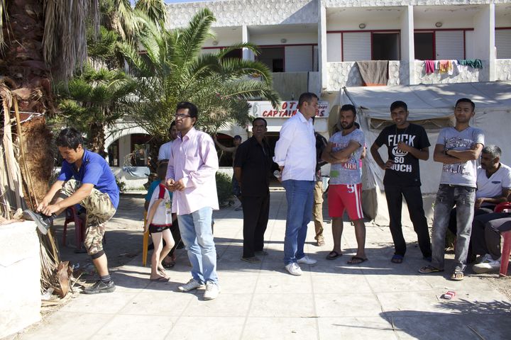 Des migrants regardent la rue depuis l'entr&eacute;e de l'ancien h&ocirc;tel Captain Elias le 19 ao&ucirc;t 2015 &agrave; Kos (Gr&egrave;ce). (BENOIT ZAGDOUN / FRANCETV INFO)