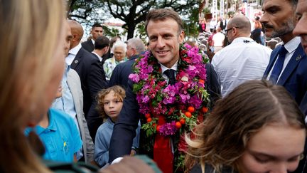 Emmanuel Macron salue les gens après avoir prononcé son discours place des Cocotiers à Nouméa le 26 juillet 2023. (LUDOVIC MARIN / AFP)