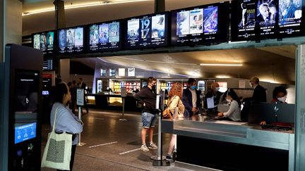 Des spectateurs réservent leur place de cinéma le 29 avril, à l'annonce de la réouverture des salles, prévue le 19 mai 2021, par Emmanuel Macron. (THOMAS COEX / AFP)